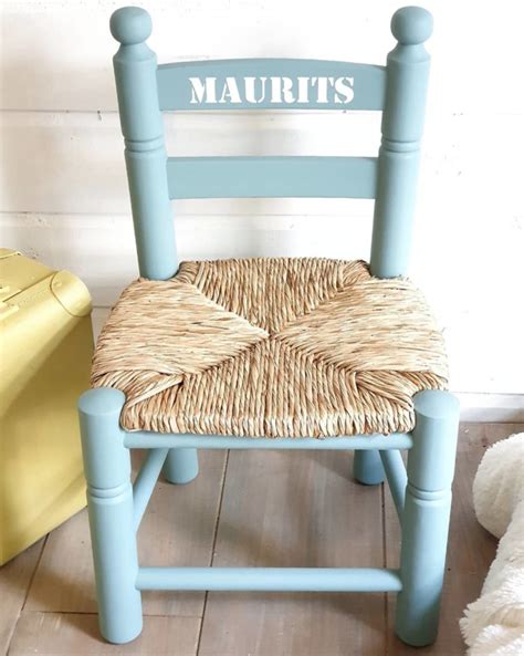 Een selectie van diverse rotan en houten kinderstoeltjes, sommigen met naam