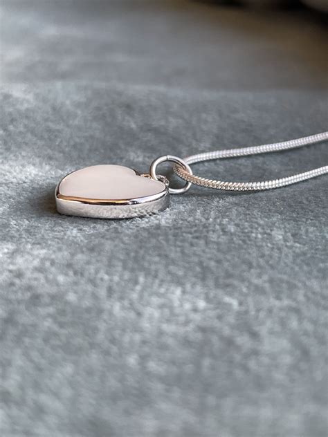 illustratie van een druppelvormige moedermelk hanger met een zachte gloed