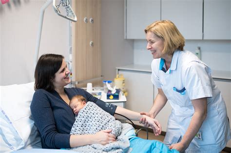 Historische foto van een vroedvrouw met moeder en baby in Haarlem