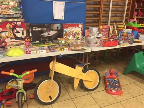 Illustratie van diverse tweedehands kinderspullen zoals speelgoed, kleding en kinderwagens.