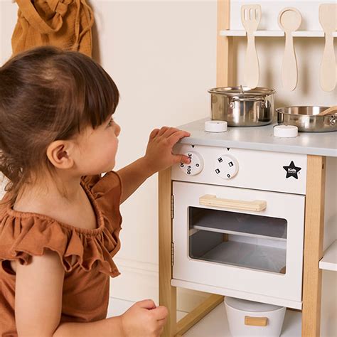 Kinderen spelen met een houten speelgoedkeuken