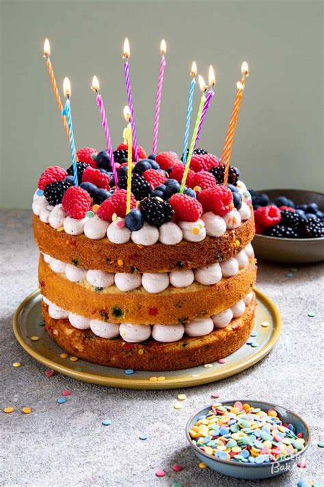 Een prachtig versierde verjaardagstaart met fondantfiguren en kaarsjes.