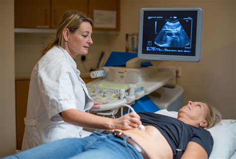 Illustratie van een echoscopieapparaat met geluidsgolven die de baarmoeder en foetus in beeld brengen.