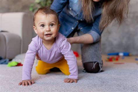 Baby die zelfstandig uit een box kruipt via een kruipluik