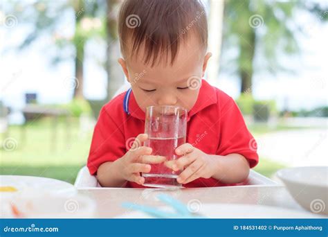 Een kind dat water drinkt uit een waterkan met fruit