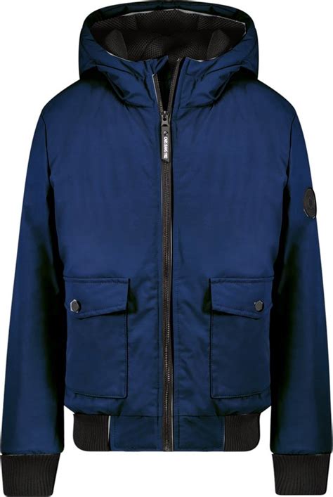 Een jongetje in een stoere, donkerblauwe winterjas met capuchon.