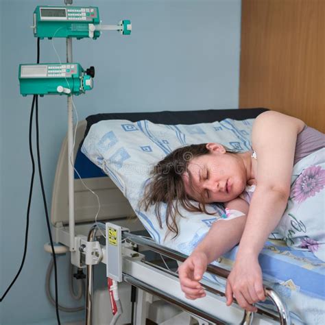 Boek 'Bevallen zonder pijn' op een nachtkastje naast een slapende zwangere vrouw.