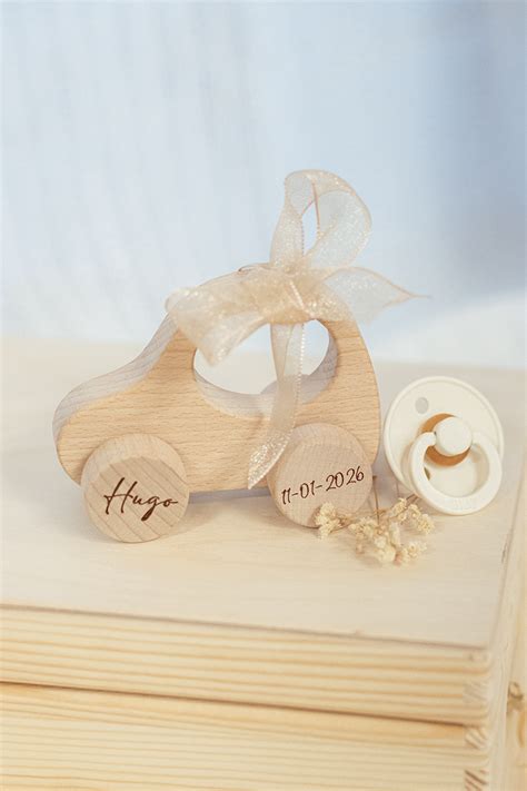 Voorbeelden van gepersonaliseerd babyspeelgoed met naam, zoals een houten autootje en een knuffeldoekje