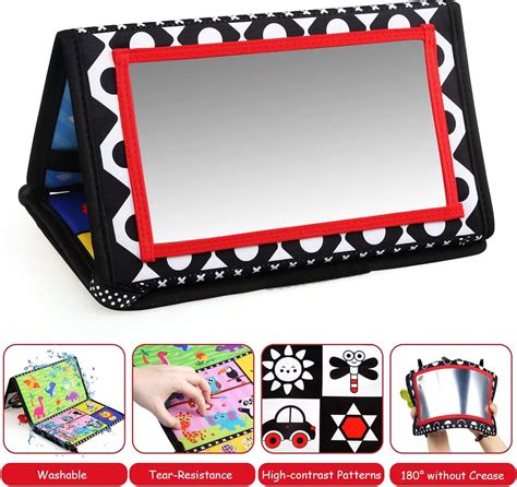 baby die naar een speelgoed spiegel kijkt in de box