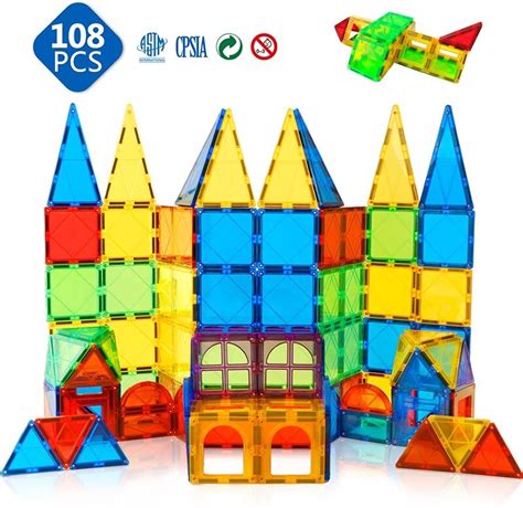 Een kind van ongeveer 3 jaar die met magnetische tegels bouwt.