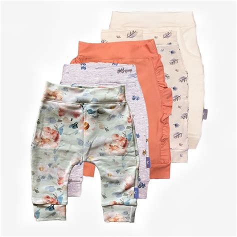 Een selectie van diverse babykledingstukken in maat 80, waaronder rompertjes, broekjes en jumpsuits.