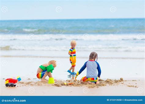 Kinderen die spelen op het strand, vastgelegd in een artistieke zwart-wit foto.