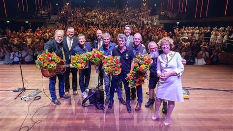 Foto van de vijf bandleden van Baby Blue op een podium met energieke uitstraling.
