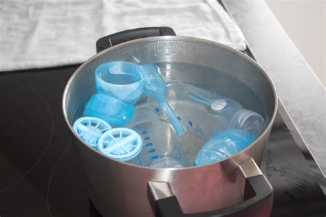 Diagram dat het proces van het uitkoken van babyflessen in een steelpan illustreert, met aandacht voor het drijven van plastic flessen.