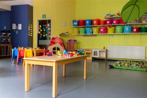 Interieur van een kinderdagverblijf: speelgoed, kleurrijke muren en kinderen die spelen