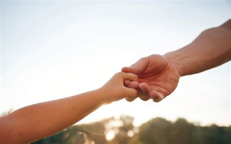 Symbolische afbeelding van een hand die een kleinere hand vasthoudt, passend bij het thema afscheid.
