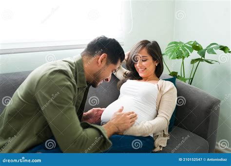 Een vader die zachtjes de buik van zijn zwangere vrouw aanraakt