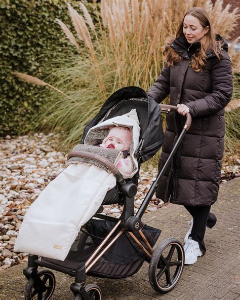 Baby in een voetenzak in een kinderwagen