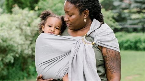 Foto van een ouder die een baby in een ringsling draagt, met de focus op het gemak.