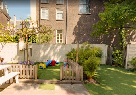 Kinderen spelen in de groene tuin van Kinderdagverblijf Het Kuikennest.