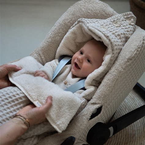 Close-up van de Koeka Wafel Antwerp autostoelhoes in natural, met zichtbare textuur en kleine zwarte puntjes.