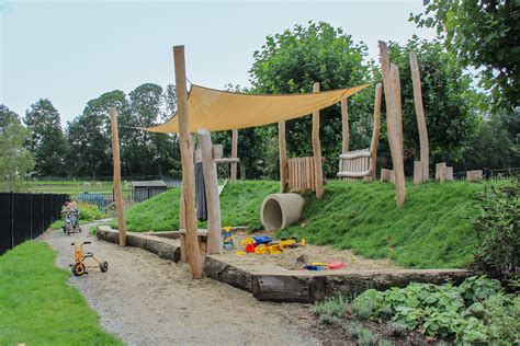 Overzicht van de buitenruimte bij Kinderopvang Liefjes Moerwijk met speeltoestellen en groen