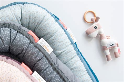 Collage van verschillende Done By Deer babynestjes in diverse patronen en kleuren, met focus op de zachte materialen en het geborgen ontwerp.