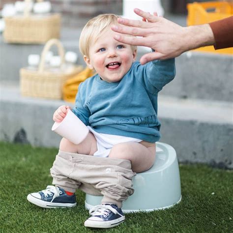 Illustratie van een baby die vrolijk op een potje zit.