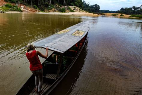 Een toeristische boot vaart door de weelderige jungle van Taman Negara.