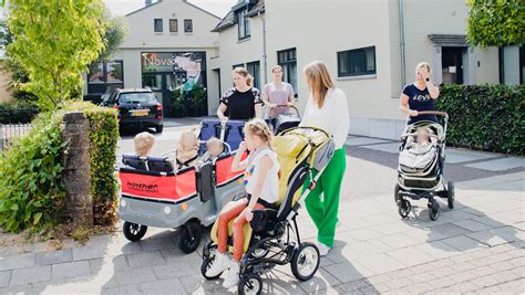 Foto van de buitenkant van het medisch kinderdagverblijf, met parkeerplaatsen en een speelplein.
