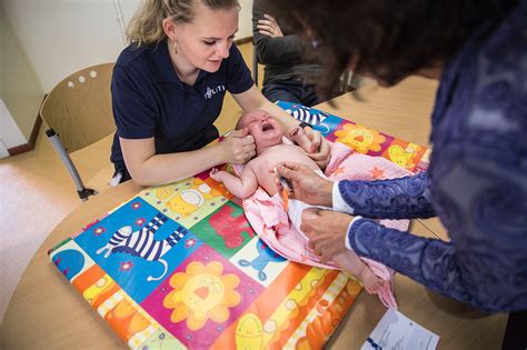medewerker van consultatiebureau onderzoekt baby