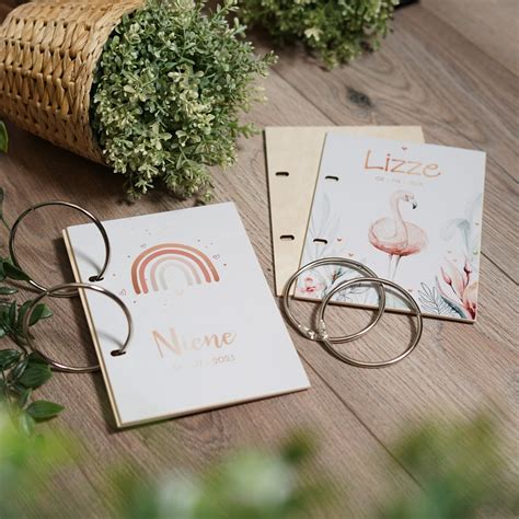 Een open bewaarbundel met geboortekaartjes, met een perforator en lint ernaast