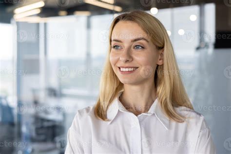 Een zwangere vrouw kijkt met een glimlach naar een echobeeld van haar baby.