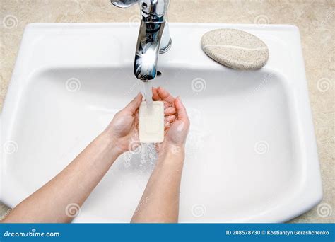 Illustratie van handen die grondig worden gewassen met zeep en water, als voorbereiding op het vasthouden van een baby.