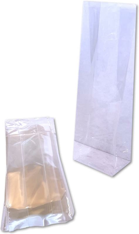 Gedetailleerde foto van een celofaan zakje met een papieren babyhoofdje, ballon en doosje rozijntjes