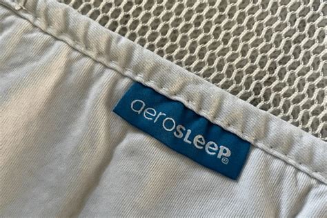Illustratie van een baby die comfortabel slaapt op een matras met een AeroSleep beschermer, met nadruk op de 3D-technologie voor ventilatie.