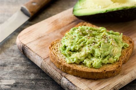 baby die een boterham met avocado eet