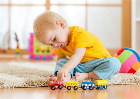Een kind dat geconcentreerd speelt met therapeutisch speelgoed in een spelkamer.