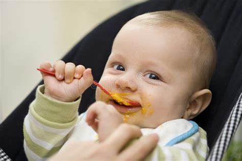 Baby die een groentehapje eet uit een lepel
