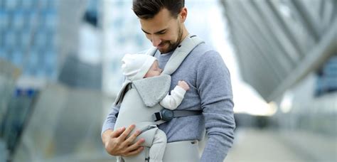 Een baby die comfortabel in de Infantino Zip Travel draagzak zit, met de kikkerhouding duidelijk zichtbaar.