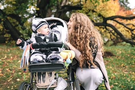 Een baby in een kinderwagen met een grote zonnekap die schaduw biedt.