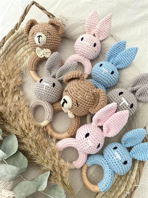 Een wagenspanner met diverse speeltjes, zoals rammelaars en zachte figuurtjes, hangend aan de kap van een kinderwagen.