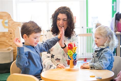 Foto van een kind dat lachend speelt met een pedagogisch medewerker.