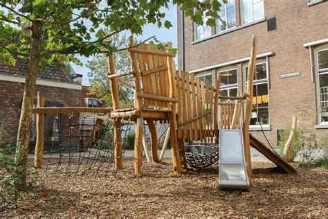 Een kindvriendelijke tuin met speeltoestellen en natuurlijke elementen, gericht op spel en ontdekking.