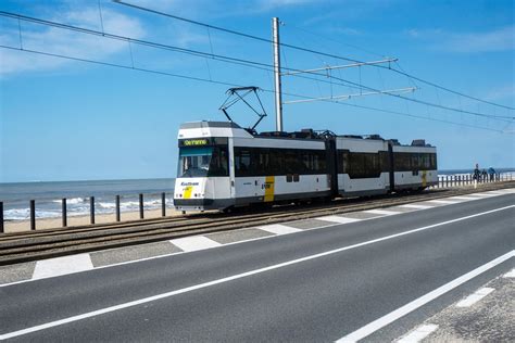 Een moderne kusttram die langs de kustlijn rijdt met op de achtergrond de zee.