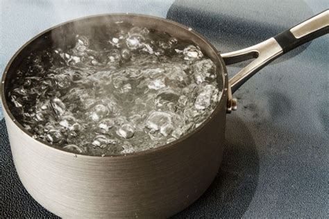 Illustratie van babyflessen die in een pan met kokend water worden uitgekookt.