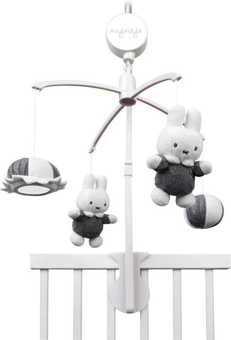 Illustratie van een grijze Nijntje muziekmobiel met draaiende figuurtjes boven een babybedje