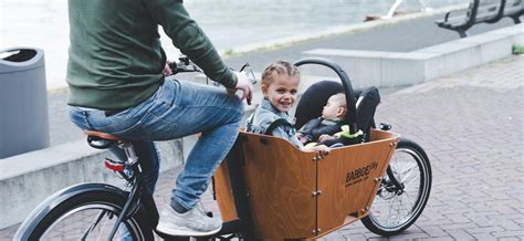 Illustratie van een baby in een Maxi-Cosi gemonteerd in een bakfiets.