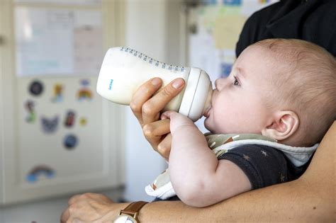 Illustratie van een baby die rustig uit een flesje drinkt na het gebruik van Gelilact.
