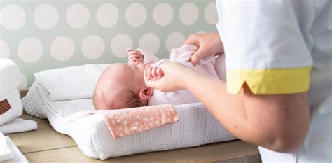 Illustratie van een kraamverzorgende die een baby verzorgt, met op de achtergrond een tevreden gezin.